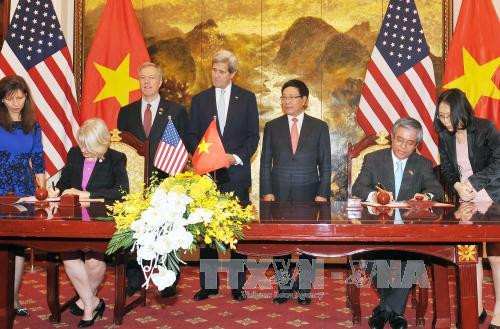  越南政府副总理兼外长范平明与美国务卿约翰·克里见证两国谋合作协议签字仪式。