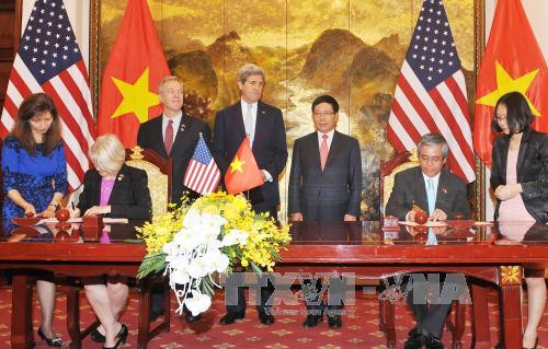  越南政府副总理兼外长范平明与美国务卿约翰·克里见证两国谋合作协议签字仪式。
