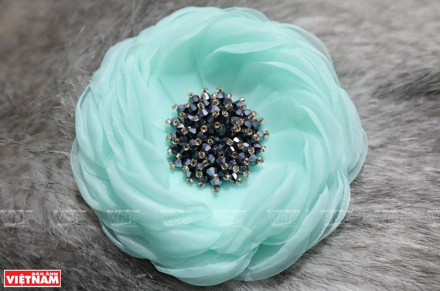 样式和颜色丰富多样的花朵胸针颇受女人的喜爱。图片来源：越通社/越南画报