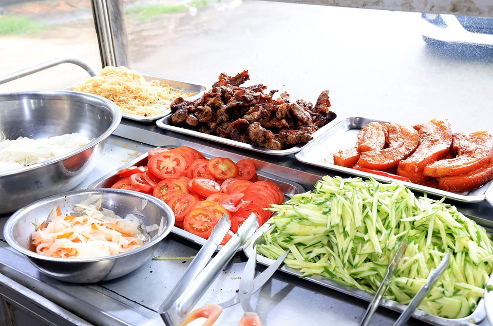 碎米饭配菜一般是加入肉末、木耳、香菇的蒸蛋，切成矩形上碟。尤其不可缺少的是木炭烧烤的糖醋排骨。图自越通社