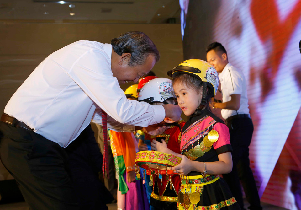 越南政府副总理张和平向小学生们赠送安全帽（越通社记者尹晋 摄）