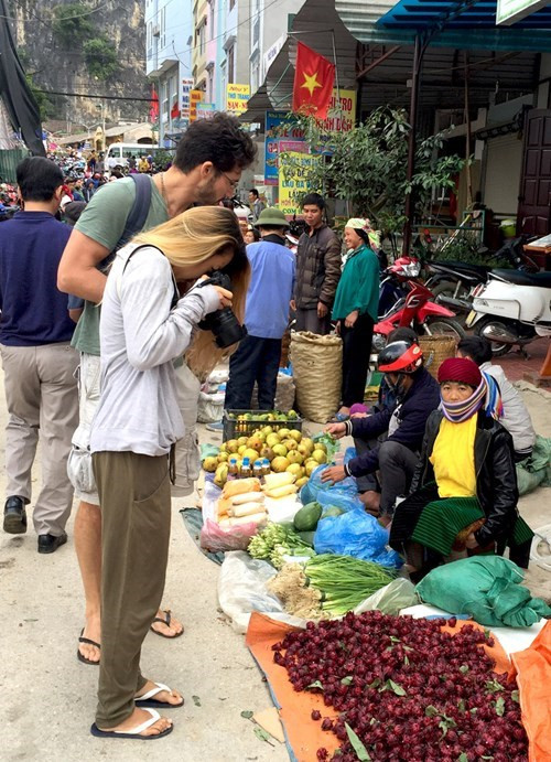 外国游客赶集市并拍下留念照。（图片来源：人民军队报）