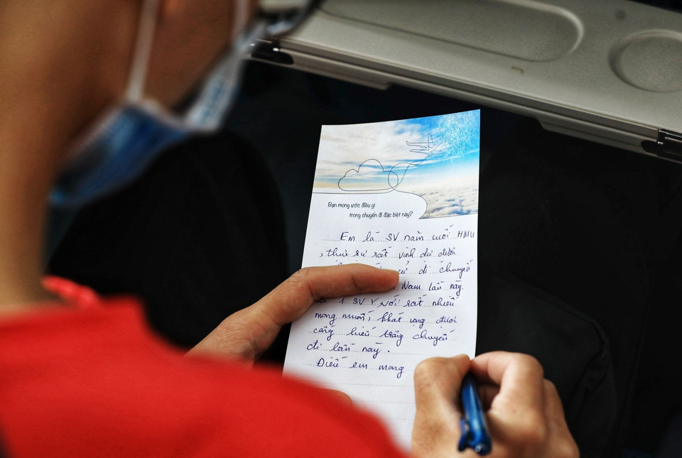 在飞机上，一些大学生给亲人写信。图自越通社