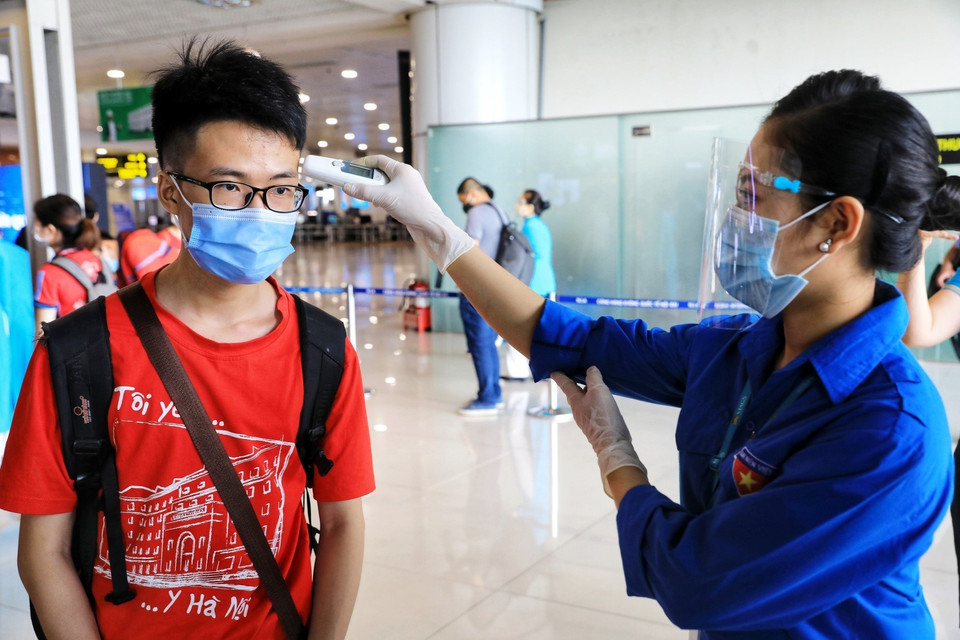 上飞机前，内排机场人员为350名大学生和教师测量体温。越通社记者 成达 摄