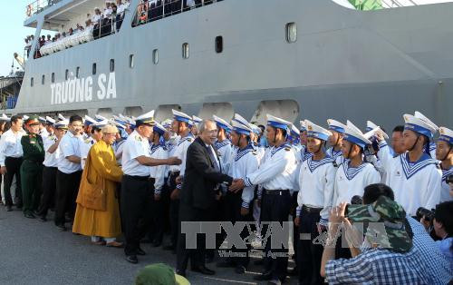 庆和省人民委员会副主席陶功天向前往长沙岛县的干部和战士们送鲜花。（图片来源：越通社）