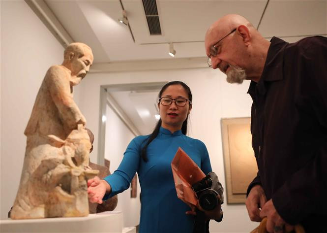 一名国际朋友倾听讲解员解释有关胡志明主席雕刻作品的意义。图自越通社