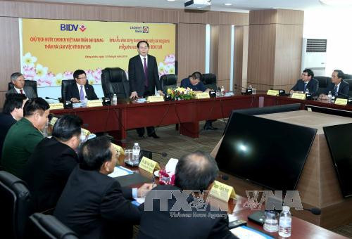 陈大光主席与老越银行工作人员亲切交谈。（图片来源：越通社）