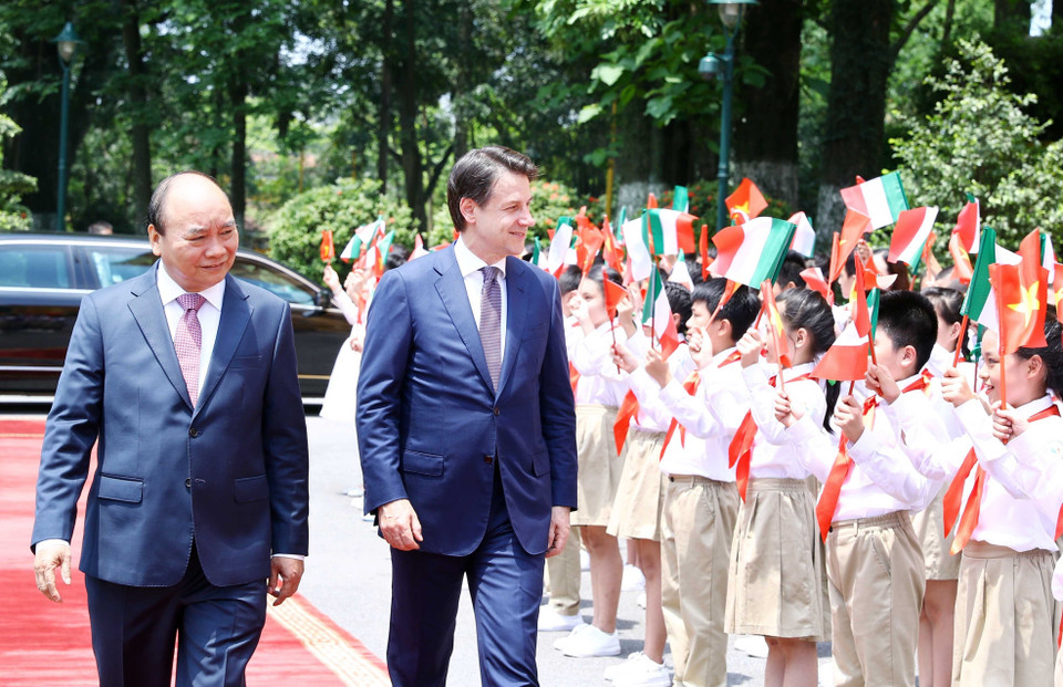 儿童们双手挥舞着越意国旗，热烈欢迎意大利总理朱塞佩•孔特来访。图自越通社