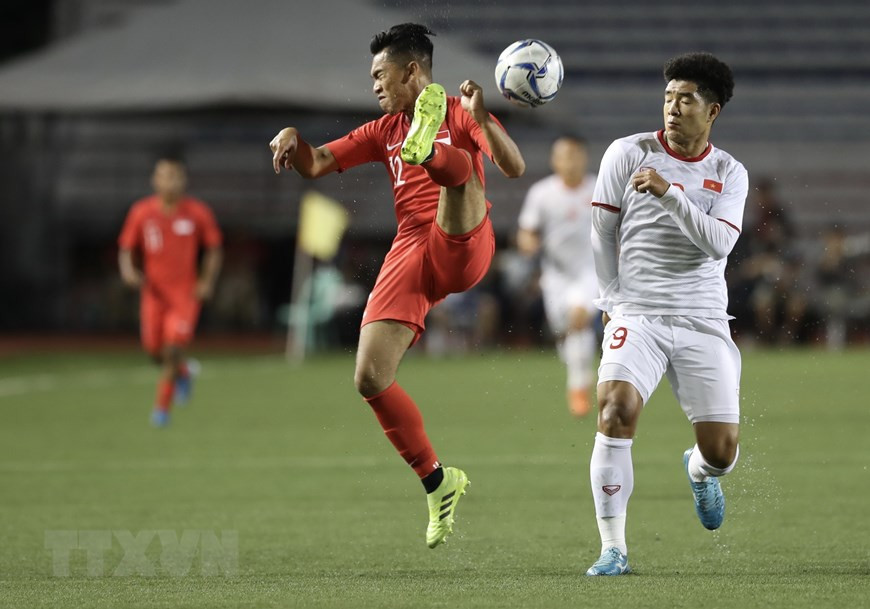 新加坡队在中场安排大量球员，采取高强度"压迫式"打法应对兴致勃勃的越南球员。(越通社 黄玲 社）