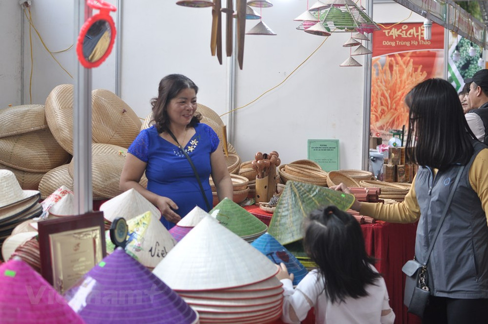参观者走访展示斗笠产品的展位。越通社记者 越德 摄