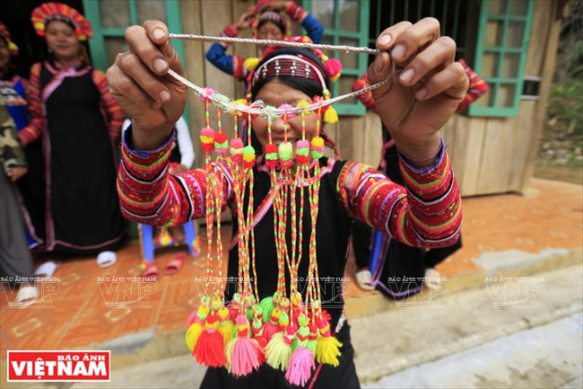 接着，用一条彩色松紧带包住头发尾部并缠在头上。最后，戴上五彩缤纷的流苏。图自 越通社/越南画报