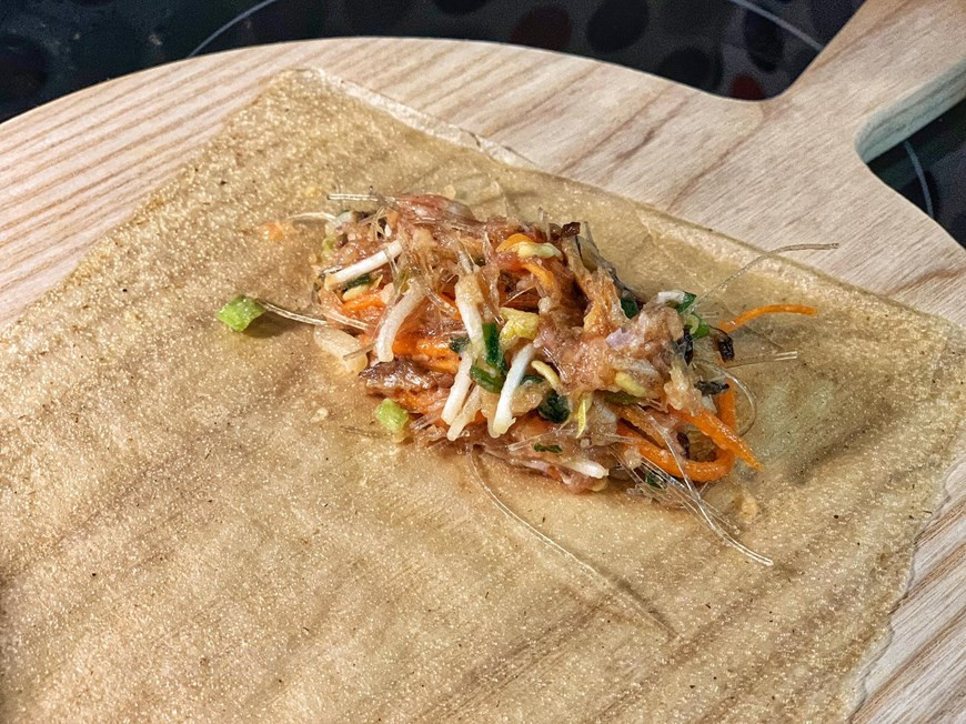 把材料放在河静省米皮上并小心卷起。图片来源：Vietnam+