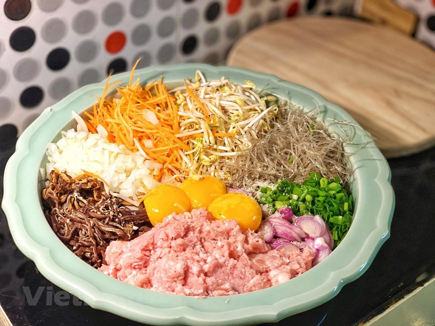 用热水泡粉丝、木耳和香菇，然后削成丝，再将水沥干。图片来源：Vietnam+