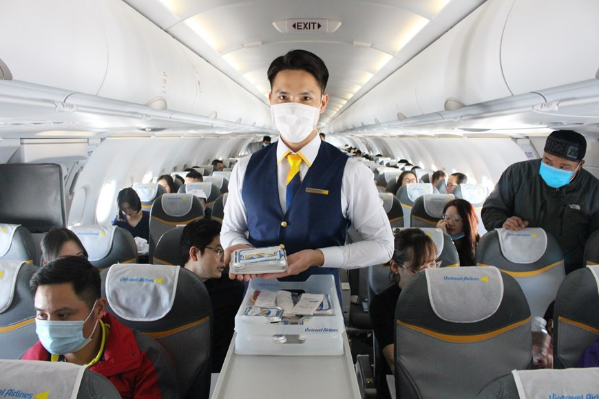 空姐在飞机上为乘客送餐。图片来源：越通社Vietnam+