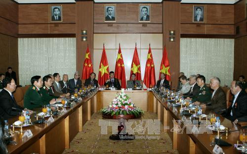 12 月 14 日下午在越南河内，越共中央政治局委员、国防部长冯光青大将会见了由黄伯秋先生率领的中国援越老战士代表团。（图片来源：越通社）