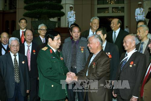 12 月 14 日下午在越南河内，越共中央政治局委员、国防部长冯光青大将会见了由黄伯秋先生率领的中国援越老战士代表团。（图片来源：越通社）