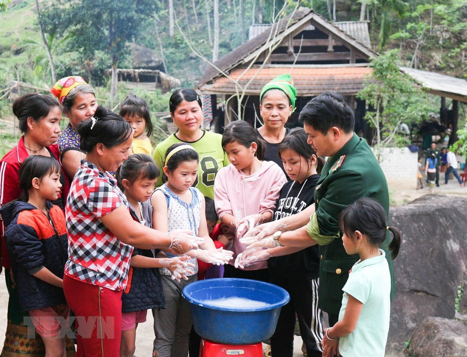 乂安省桂风县幸译边防哨所部队战士引导当地居民正确地洗手，以防控新冠肺炎疫情。图自越通社