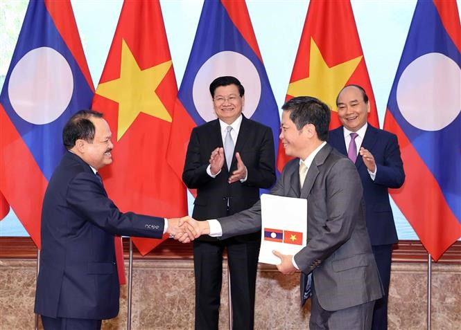 阮春福总理与老挝总理通伦•西苏里共同见证2021年越老合作计划协议以及越老政府间联合委员会第43次会议纪要签字仪式。图自 越通社