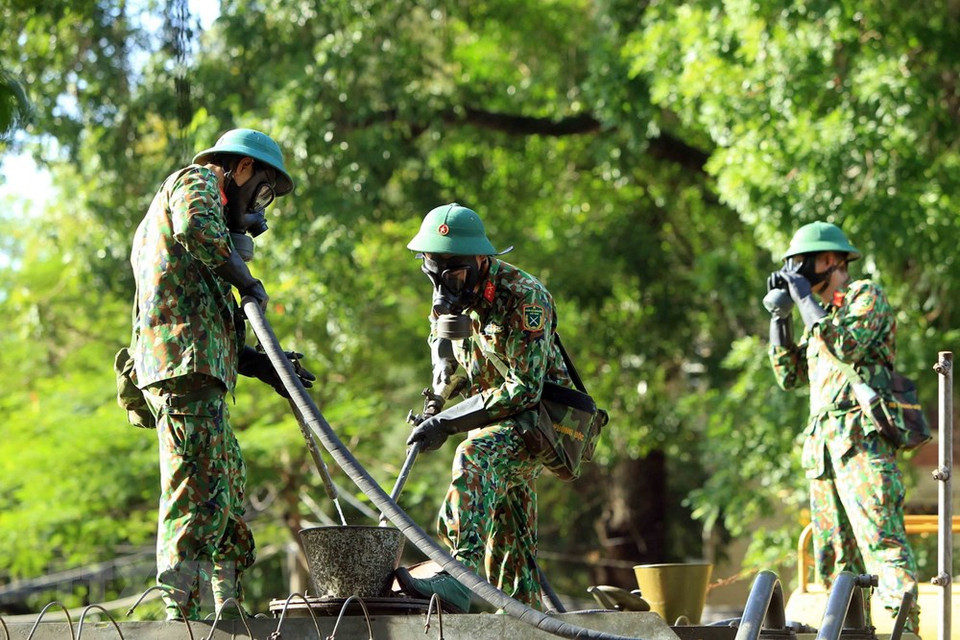 为了做好新冠肺炎疫情防疫工作，海防市第三军区司令部化学兵种力量在海防市各条街道喷洒消毒液，以防控疫情扩散蔓延。图自越通社