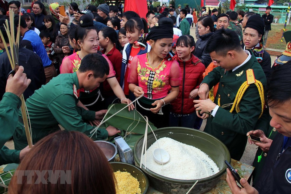 山罗省战士们和各民族同胞一起包粽子。图自越通社