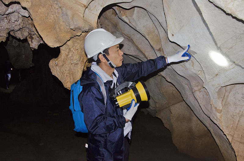 下龙湾管理委员会干部对该洞进行仔细考察，为其提出保护与发挥价值的措施。（图片来源：《人民报网》）