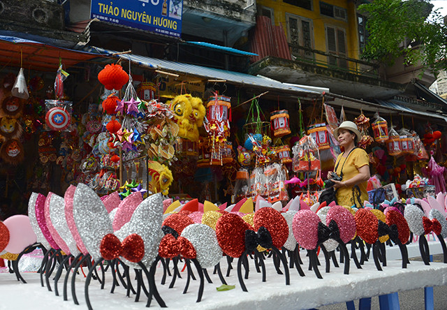 古街摆满了面具、五角星灯、纸灯笼、狮子头等越南中秋节传统玩具。（图片来源：越南《人民报网》）