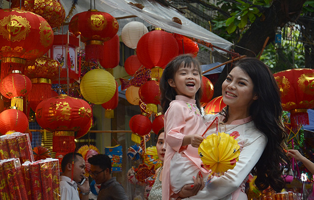 许多父母带儿女去购买中秋礼物，并让孩子们体验中秋节的气氛。（图片来源：越南《人民报网》）