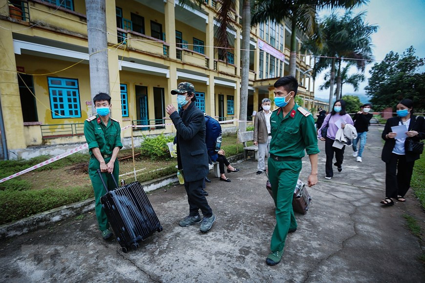 战士们帮助公民把行李箱送上车上车。（越通社记者仲达 摄）