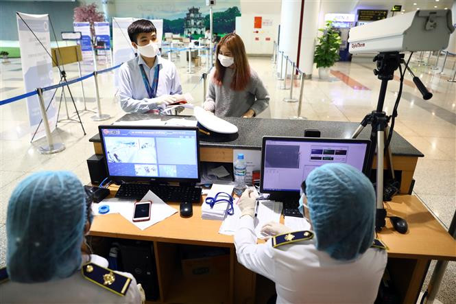 进行健康申报和体温测量之后，医护人员要对每一位入境越南的旅客提取测验样本。越通社记者辉雄 摄