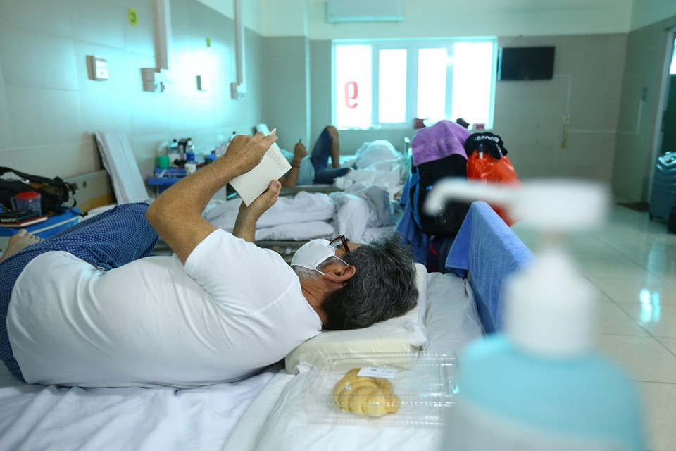 接受隔离观察的游客看书或使用手机来打发时间。越通社记者 明决 摄