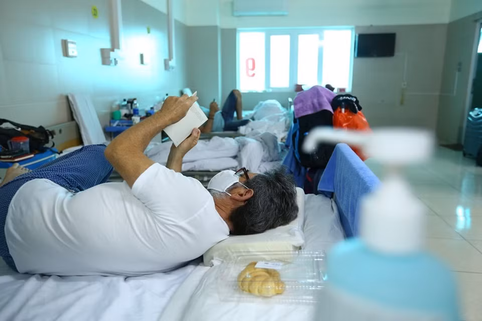 接受隔离观察的游客看书或使用手机来打发时间。越通社记者 明决 摄