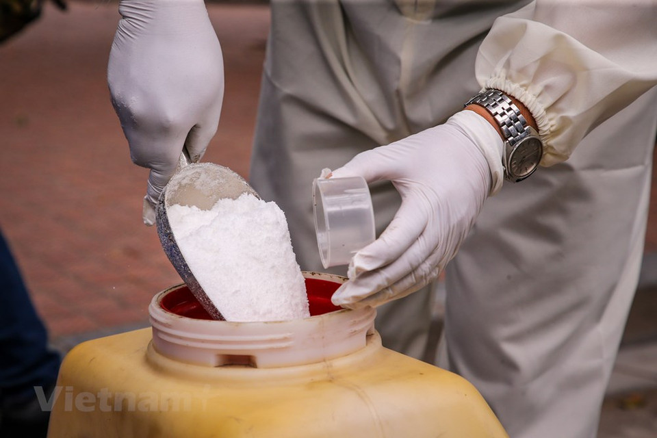 3个消毒人员将陆续使用氯胺素B进行消毒。图自越通社