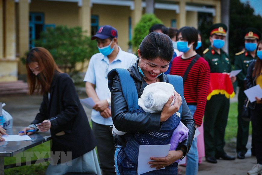 在疫情在韩爆发的背景下，现在才4个月的刘何眉被父母请人帮忙送回越南。乂安省的阮氏莹就是自愿照顾她的人。能够拿到隔离解除证书，抱着刘何眉的她感到十分幸福。（越通社记者仲达 摄）