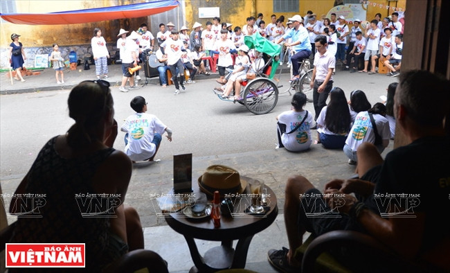 外国游客一边品尝咖啡一边观看街头艺术活动。本报记者 清和 摄