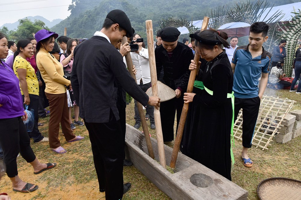 同胞们把糯米放进石臼中，用大木槌用力捶捣。（图片来源：越通社）