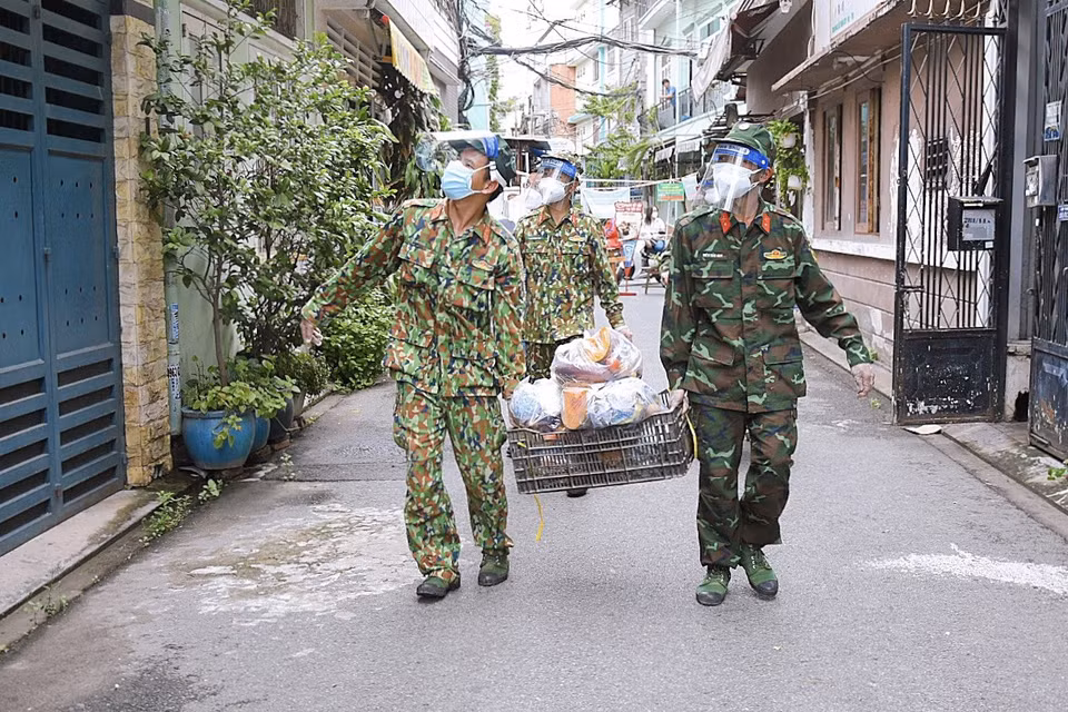 在部队战士的贴心服务之下，分配好的一包包必需品陆续到达人民手中。图自越通社。