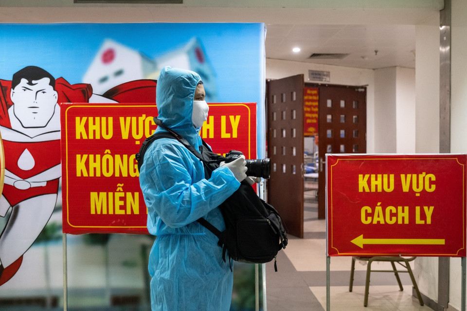 越通社摄影记者明决在越南中央血液学和输血医学院的隔离区进行报道。图自越通社