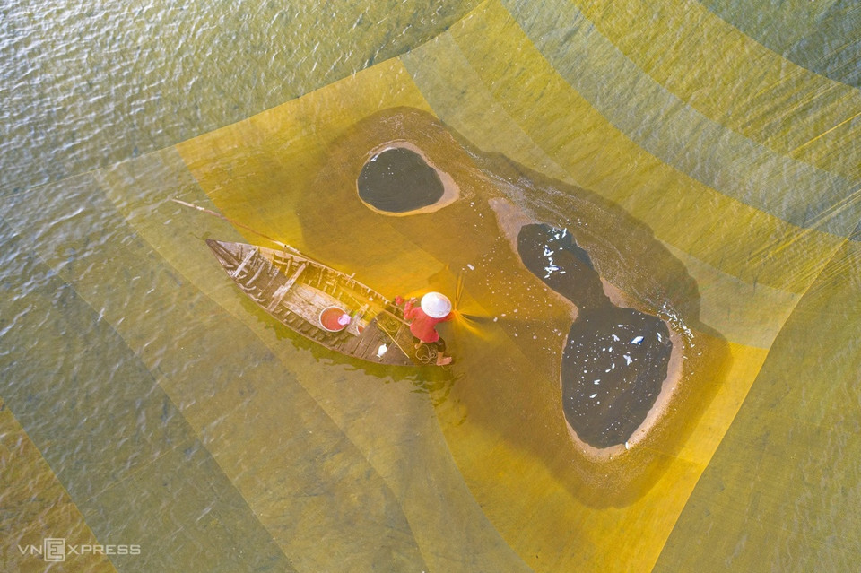 渔民在秋盆河上撒网捕捞。