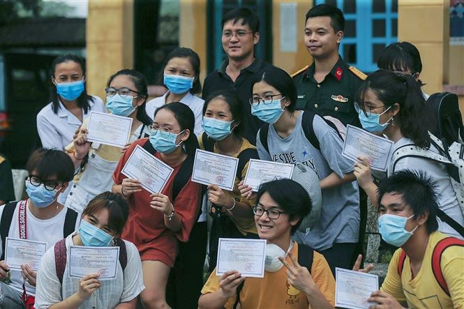 集中隔离期满的人员与和平省军事指挥部战士合影。图自越通社