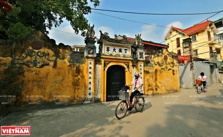 在周围高楼林立环境中，巨陀古村长满青苔的老墙显得更加安静沉稳。图自《越南画报》