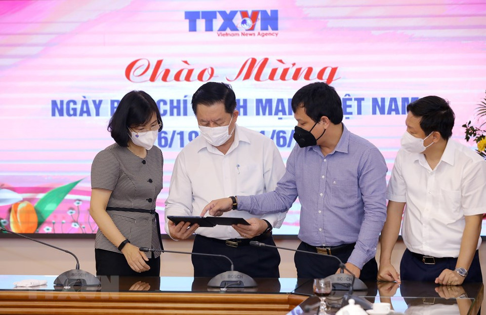 越通社副社长武越庄向中央宣教部部长阮仲义介绍越通社的电子出版物。图自越通社