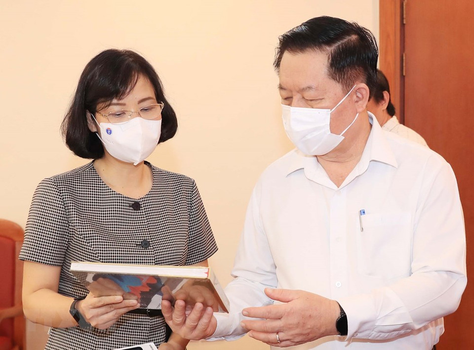 越通社副社长武越庄向中央宣教部部长阮仲义介绍越通社出版的印刷品。图自越通社