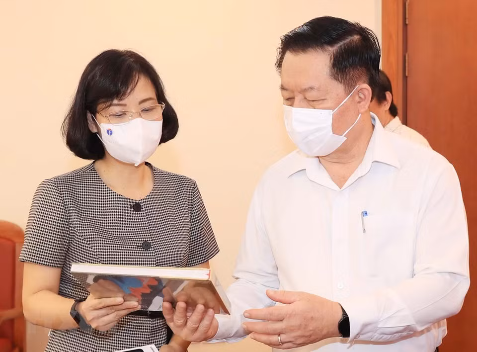 越通社副社长武越庄向中央宣教部部长阮仲义介绍越通社出版的印刷品。图自越通社