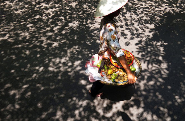 买熟仁面果的流动摊贩。（图片来源：越南《人民报网》）