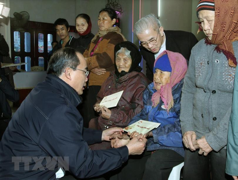 越南祖国阵线中央委员会主席阮善仁向清化省俄山县俄田乡田户教区的贫困信徒送上2015年乙末年纯洁慰问品。越通社发