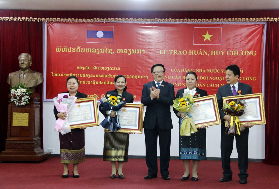 越共中央委员会委员、中央对外委员会主任黄平君（中）向老挝外交委员会干部授予越南国家主席友谊勋章。越通社发
