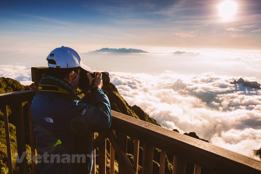 每当云彩来临时，数百名摄影师和旅游爱好者不约而同地汇聚于此，沉浸于浮云之中去体验一切情绪。天气越来越冷，但太阳升起让场景变得绚丽多彩。站在山顶，能够一眺番西邦峰的美景。那时的“印度支那屋脊”美如仙境。极目远望，山峰逶迤，白云缭绕，朦朦胧胧，给人无限的遐想。图自Vietnam+