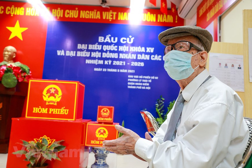 范文哥先生也是河内市各投票站最早投票的选民之一。 尽管年纪大，范文哥先生自 1946 年以来从未错过全国大选日。在全国选举日当天，选举组在进行投票前，必须宣读有关选举纪律，随后当着选民的面进行投票箱的验证、封箱，以确保公开性、客观性和人民监督的原则。这也是选民直接监督选举工作的一种方式。图自Vietnam+
