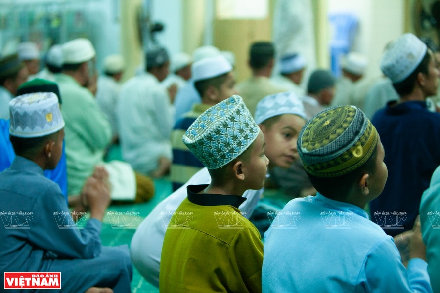 占族男孩头戴传统布帽在教堂行礼。图自越通社