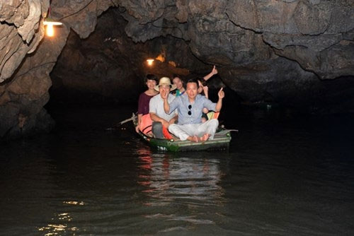 游客乘船穿山而过，观赏溶洞。（图片来源：人民军队报）